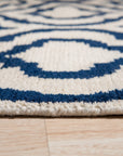 Trendy Moroccan Navy Hand Knotted Wool Rug, a navy and ivory wool rug with a geometric Moroccan design, seen in a bright living room setting.