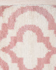 Inviting Moroccan Pink Hand Knotted Wool Rug, a soft pink wool rug with a geometric diamond pattern, seen in a bright, airy living space.