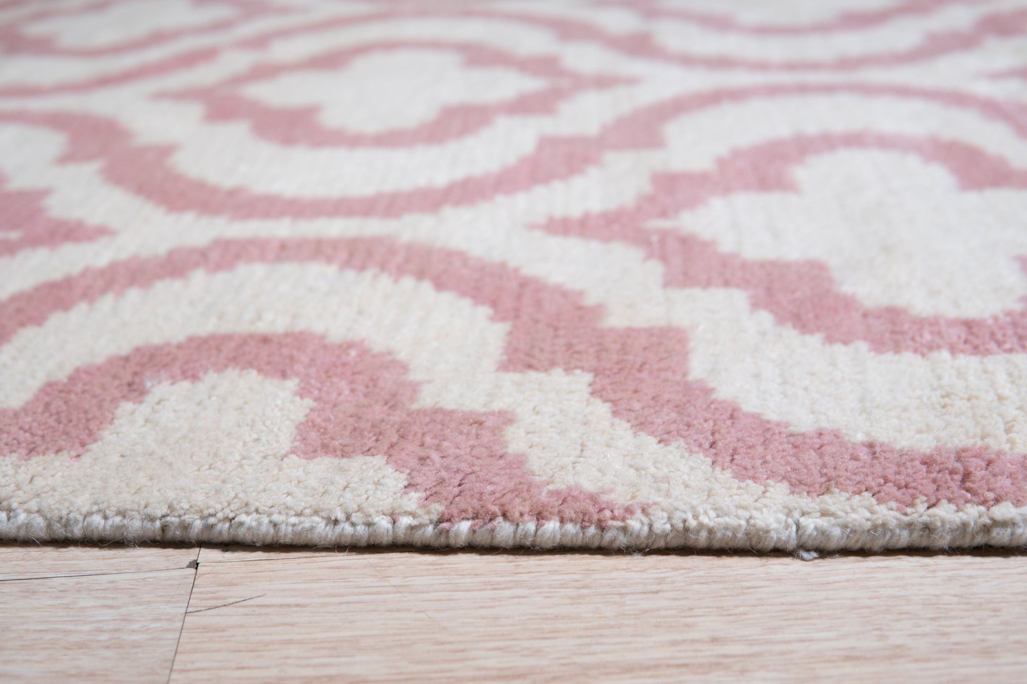 Inviting Moroccan Pink Hand Knotted Wool Rug, its blush tones and intricate Berber knotting softening a sun-drenched living room.
