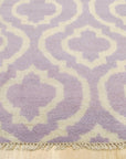 Elegant Moroccan Purple Hand Knotted Wool Rug, showcasing its intricate patterns and rich purple hues, lies beautifully textured on a light wood floor.