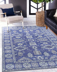 Rustic Oriental Blue Hand Tufted Wool Rug sprawls across a hardwood floor, its intricate blue patterns and hand-tufted texture adding warmth and character to the room's decor.