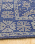 Rustic Oriental Blue Hand Tufted Wool Rug, its intricate, hand-tufted patterns swirling in shades of blue, bringing an antique-inspired elegance to the room.