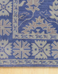 Rustic Oriental Blue Hand Tufted Wool Rug, displaying its intricate patterns and rich blues amidst warm, neutral tones in a living room setting.