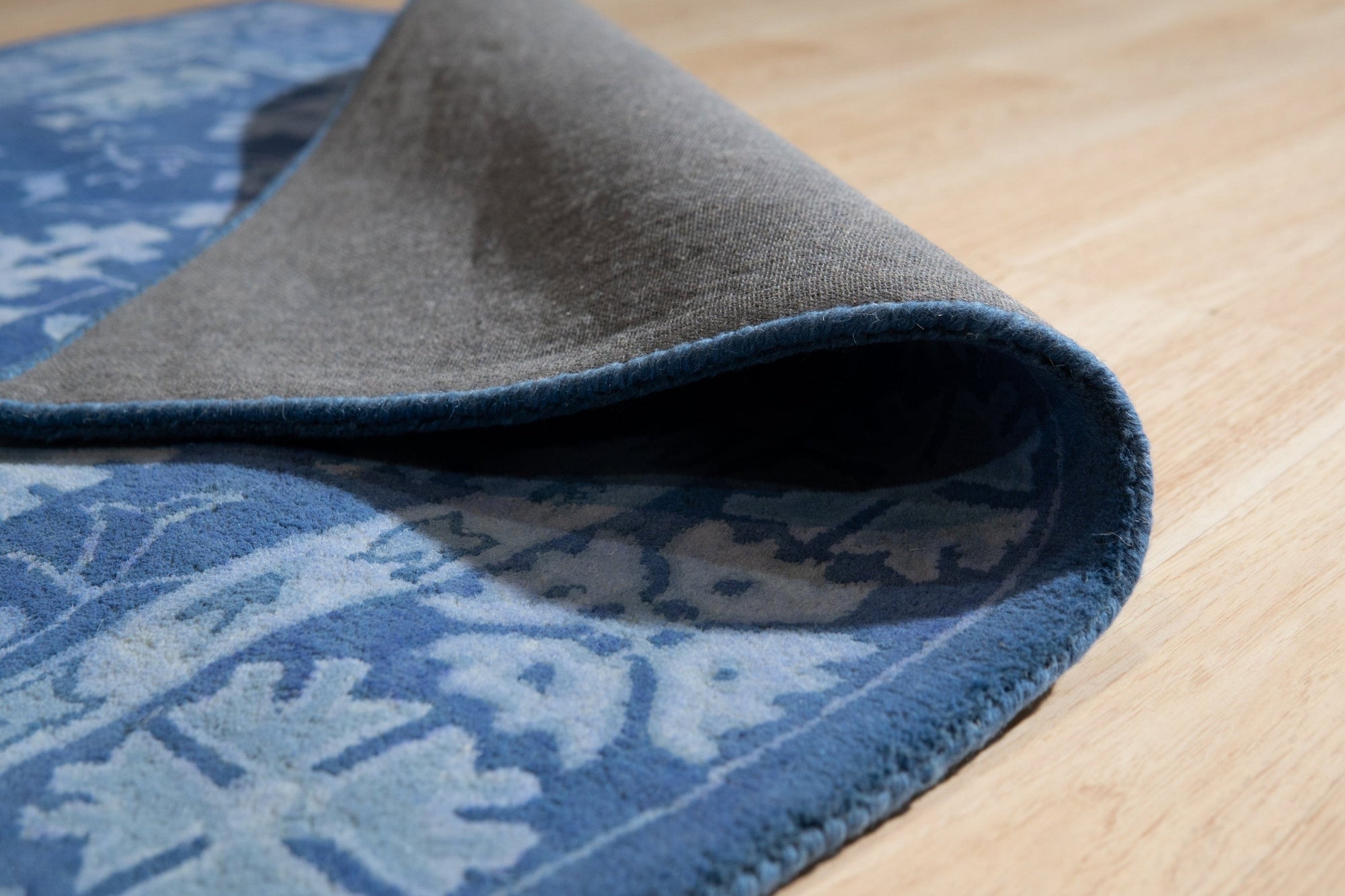 Rustic Oriental Blue Hand Tufted Wool Rug, a vibrant blue and cream wool rug with a classic oriental design, anchors a light-filled living room with modern furniture.