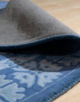 Rustic Oriental Blue Hand Tufted Wool Rug, a vibrant blue and cream wool rug with a classic oriental design, anchors a light-filled living room with modern furniture.