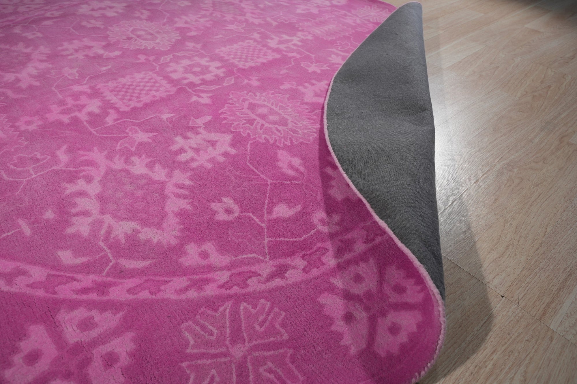 Opulent Oriental Pink Hand Tufted Wool Rug, a vision of plush comfort in a room bathed in soft light, its pink hues and intricate oriental design adding a touch of timeless elegance.