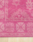 Opulent Oriental Pink Hand Tufted Wool Rug, its intricate floral design and delicate pink hues softening a bright, contemporary living space, the hand-tufted wool pile suggesting luxurious comfort.