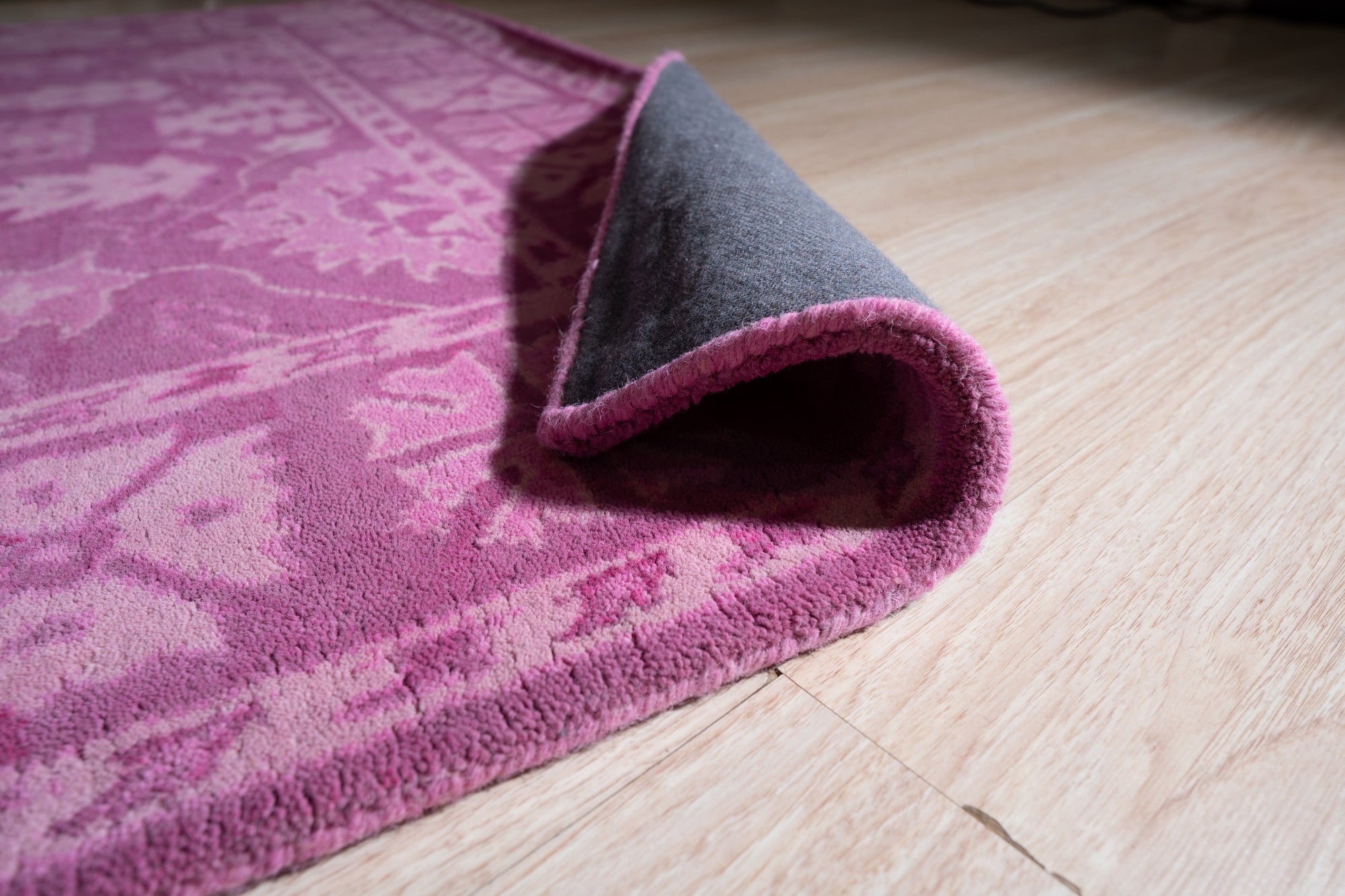 Opulent Oriental Pink Hand Tufted Wool Rug, a pink and wool rug with an oriental design, seen in a room setting with furniture, showcasing its plush texture and pattern.
