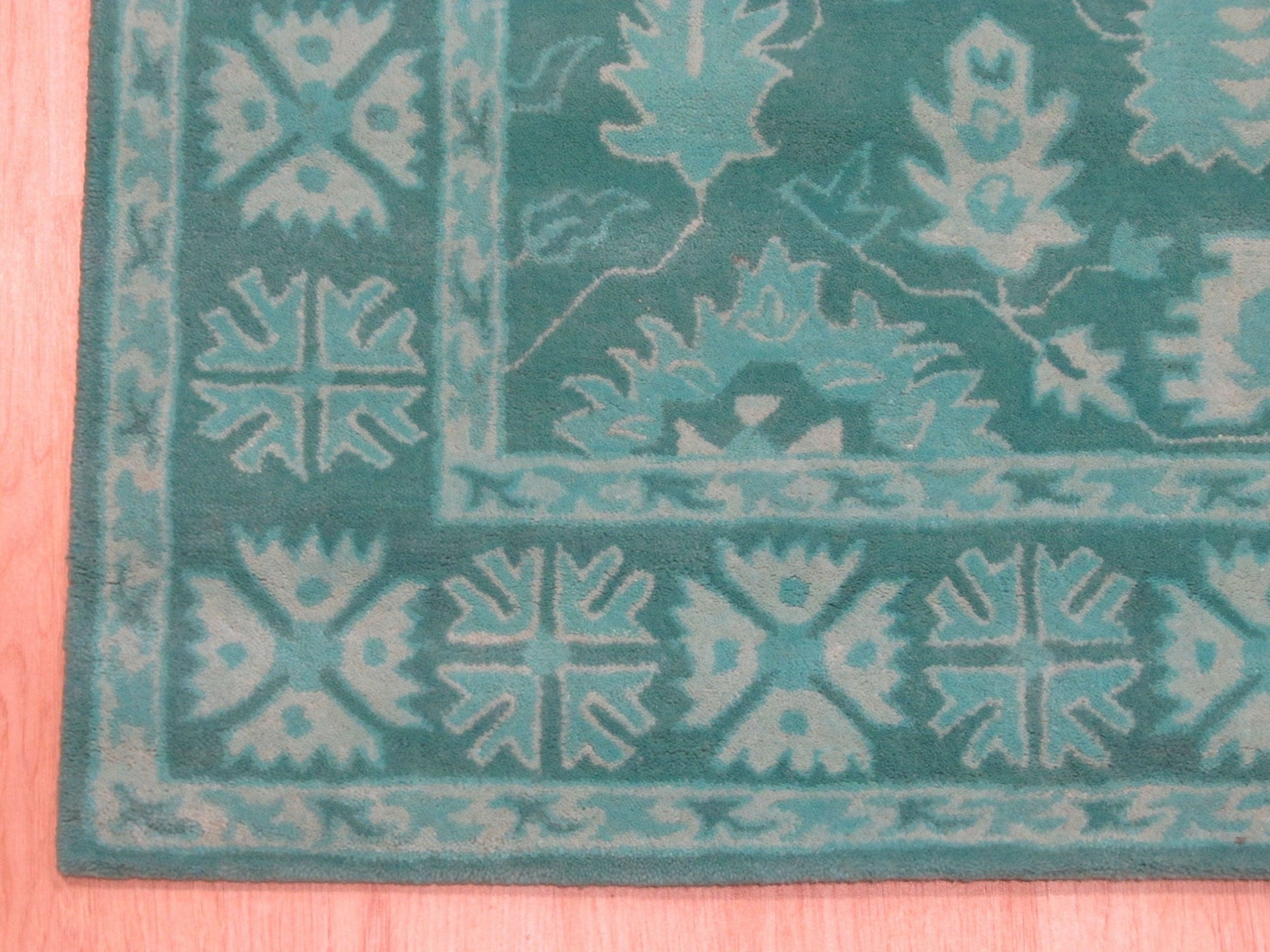 Louie Oriental Turquoise Hand Tufted Wool Rug, its vibrant turquoise hues and intricate oriental design displayed in a room setting, showcasing the rug's soft wool texture.