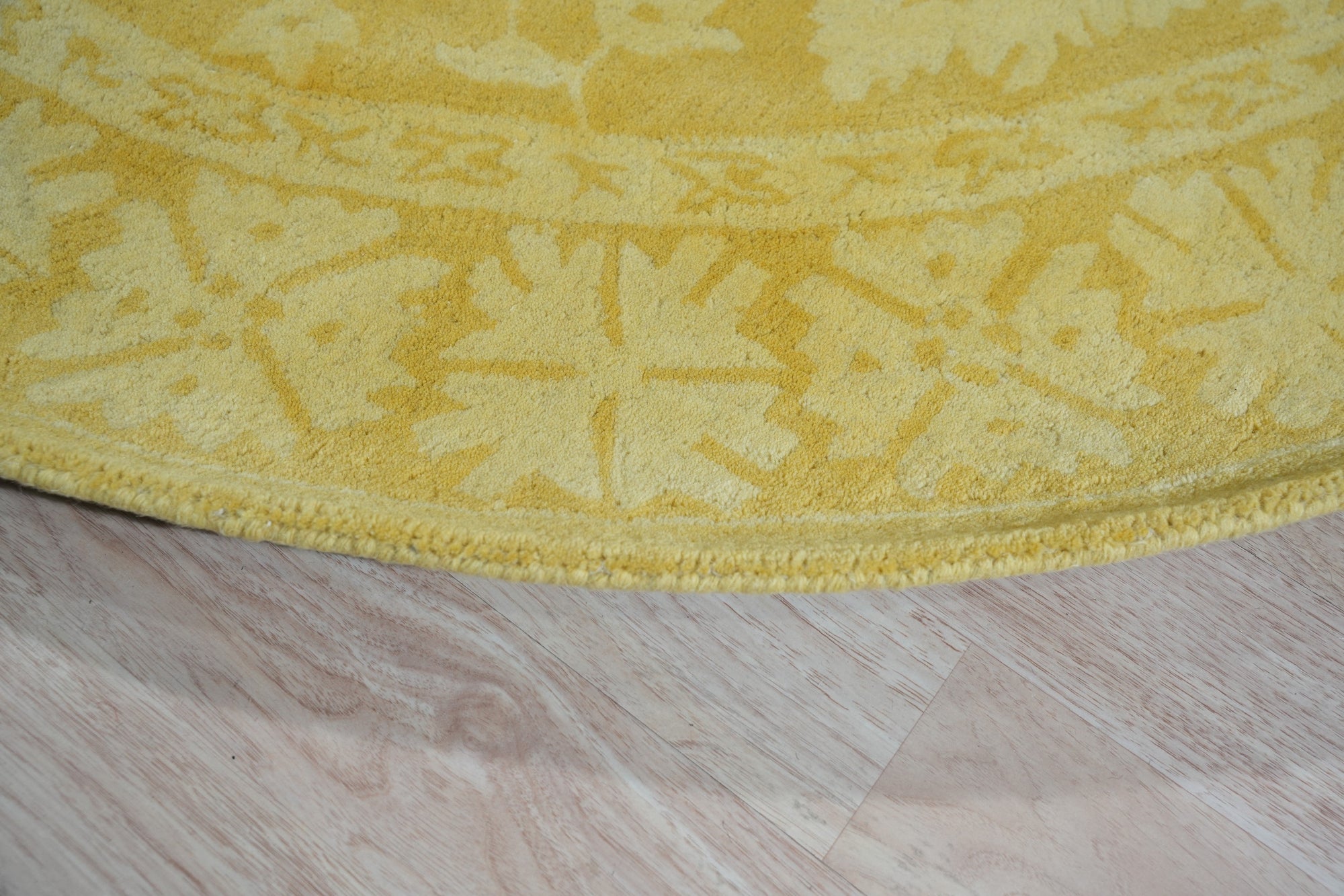 Comfortable Oriental Yellow Hand Tufted Wool Rug, warm yellow wool rug with intricate oriental designs, resting on a light wooden floor with natural sunlight illuminating its texture.