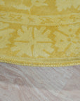 Comfortable Oriental Yellow Hand Tufted Wool Rug, warm yellow wool rug with intricate oriental designs, resting on a light wooden floor with natural sunlight illuminating its texture.