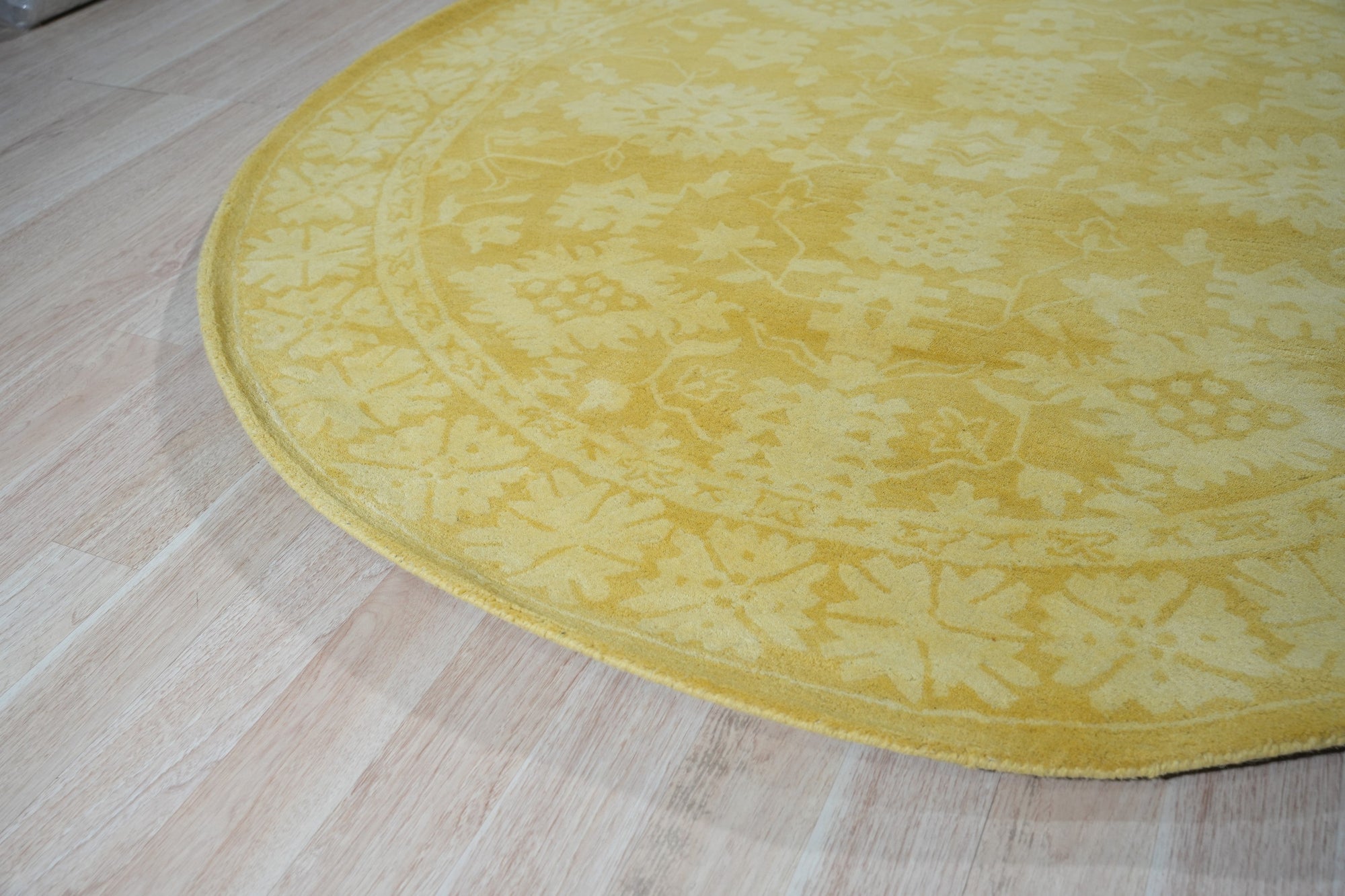 Comfortable Oriental Yellow Hand Tufted Wool Rug, a vibrant splash of sunshine yellow anchored by intricate floral motifs, hand-tufted for a luxurious, textured feel underfoot, displayed within a warmly lit living space.
