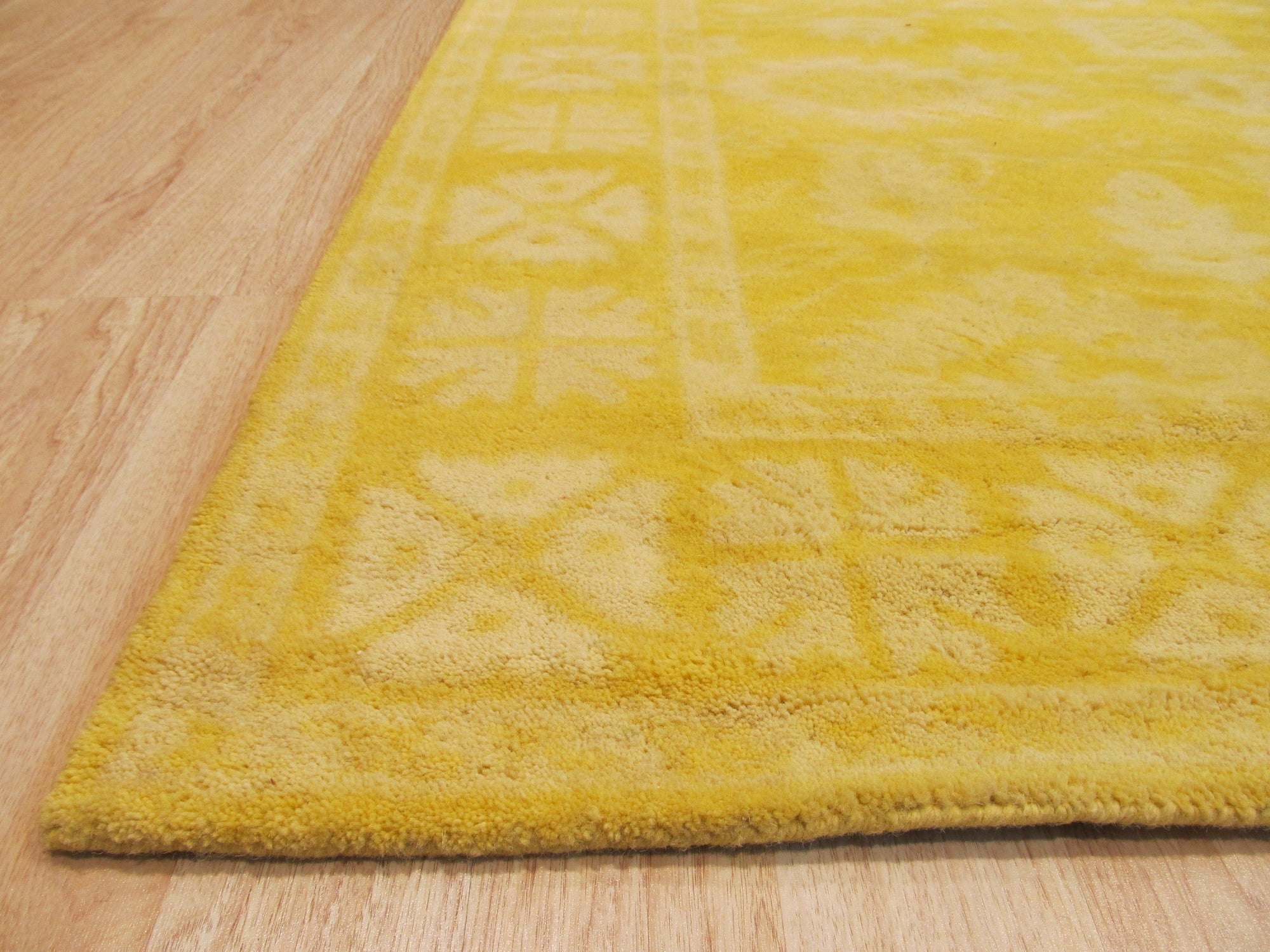 Comfortable Oriental Yellow Hand Tufted Wool Rug, showcasing its vibrant yellow hue and intricate hand-tufted design details in a cozy living room setting.