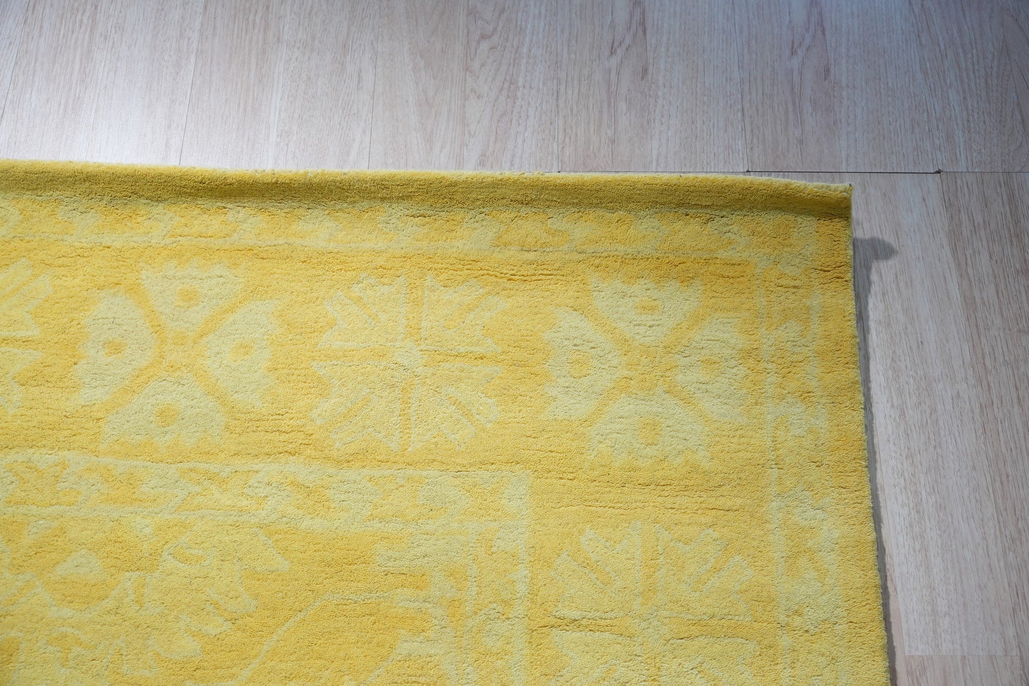 Comfortable Oriental Yellow Hand Tufted Wool Rug, radiating warmth with its golden hues and intricate design, anchors a modern living space with inviting texture.