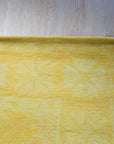 Comfortable Oriental Yellow Hand Tufted Wool Rug, radiating warmth with its golden hues and intricate design, anchors a modern living space with inviting texture.