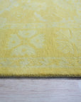 Comfortable Oriental Yellow Hand Tufted Wool Rug, warm golden hues and intricate floral patterns unfurl across this hand-tufted wool rug, its luxurious texture adding comfort and sophistication to a brightly lit living space.