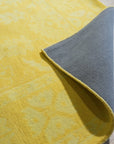 Comfortable Oriental Yellow Hand Tufted Wool Rug, vibrant yellows and intricate floral patterns bloom across a hand-tufted wool rug, softly illuminating a bright, modern living space.