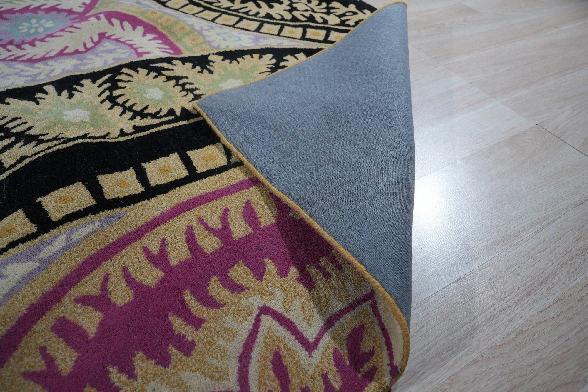 Opulent Nina Black Hand Tufted Wool Rug, showcasing its intricate geometric pattern of cream on black, creating a modern yet luxurious feel within a bright, airy living space.
