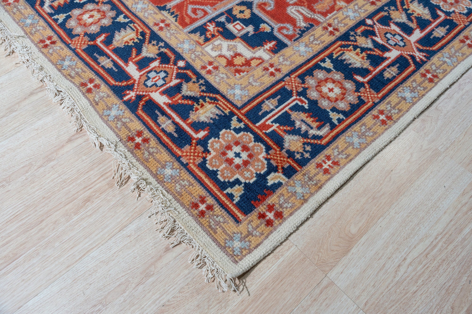 Classic Elegant Blue Hand-Knotted Wool Rug, a vibrant blue wool rug featuring intricate floral patterns, displayed in a brightly lit room with hardwood flooring, lending a sophisticated touch.