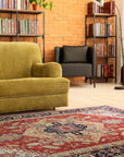 Exquisite Traditional Red Hand Knotted Wool Rug, a richly colored red wool rug with intricate traditional patterns, lies elegantly on a polished wood floor, partially obscured by a decorative, dark wood chair.