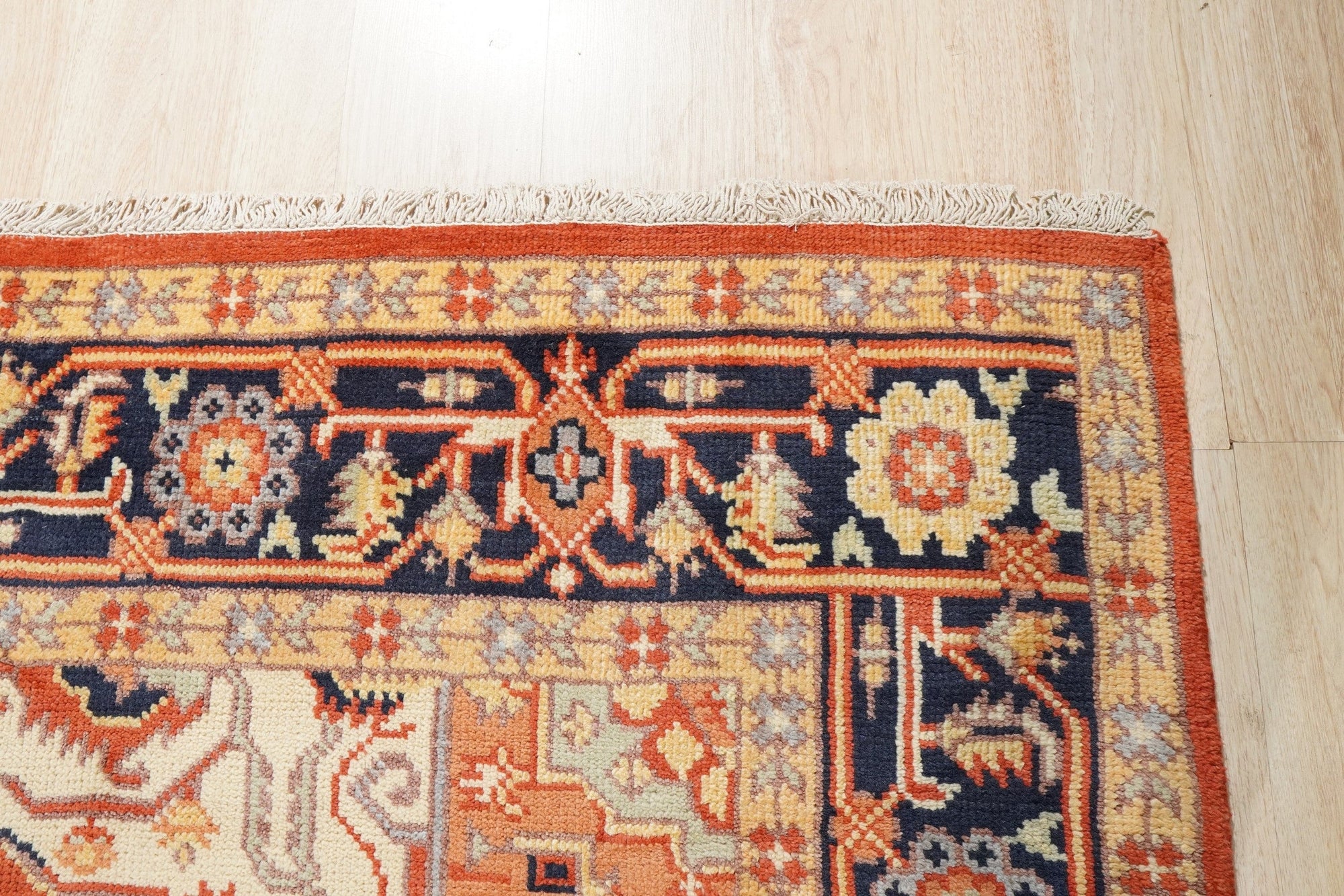 Harlow Oriental Rust Hand Knotted Wool Rug, warm rust tones and intricate oriental patterns unfurl across this hand-knotted wool rug, creating a vibrant focal point in a room setting.