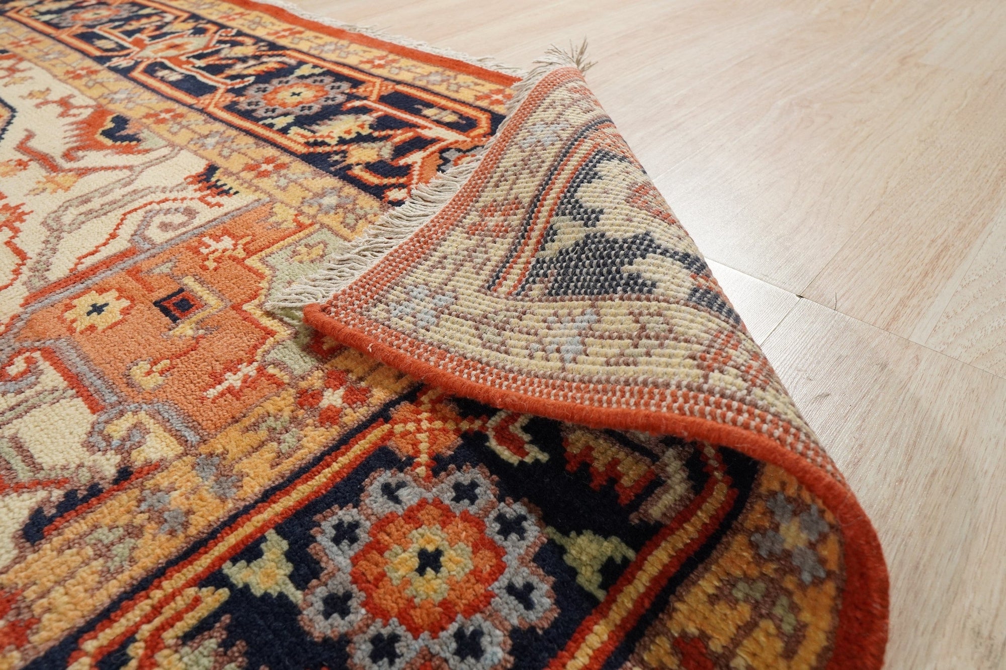 Harlow Oriental Rust Hand Knotted Wool Rug graces a warmly lit room, its intricate design and rich rust hues anchoring the space with traditional elegance. The hand-knotted wool construction is subtly highlighted, lending a sense of luxurious texture.