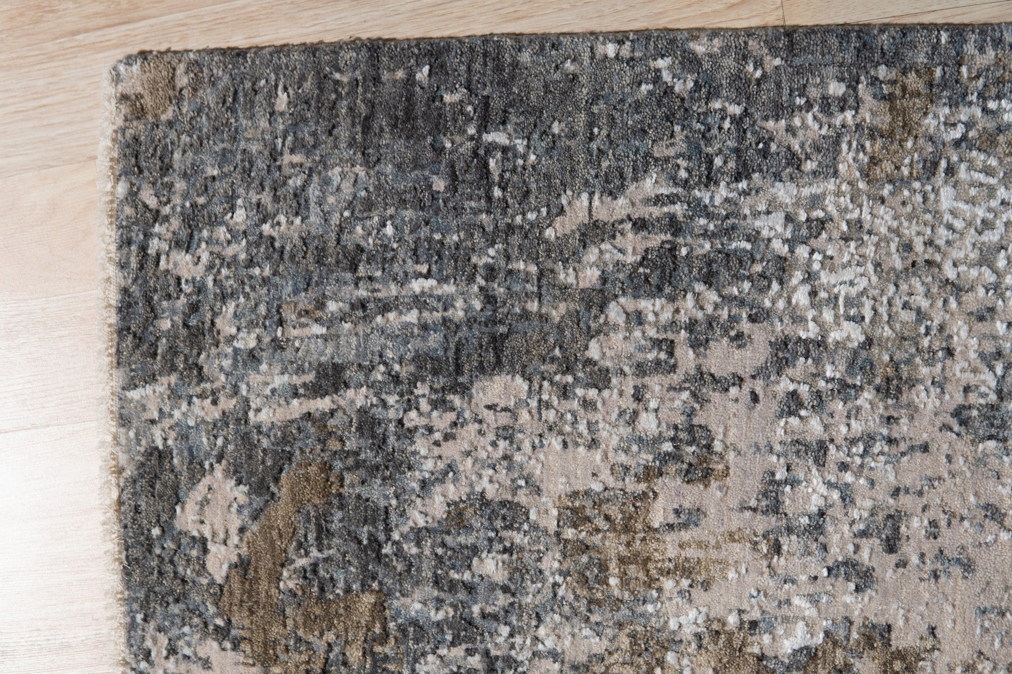 Xena Chloe Gray Hand Knotted Wool Rug, showcasing intricate knotwork and a soft, gray palette, displayed in a bright, airy living room setting.