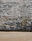 Xena Chloe Gray Hand Knotted Wool Rug displayed in a bright, modern living space. Soft gray hues mingle in the hand-knotted wool, creating a subtly textured floor covering that complements the light-filled room.