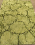 Sleek Cozy Green Hand Knotted Wool Rug, a vibrant green wool rug with subtle texture variations, lies on a light-toned floor, suggesting comfort and warmth in a minimalist space.