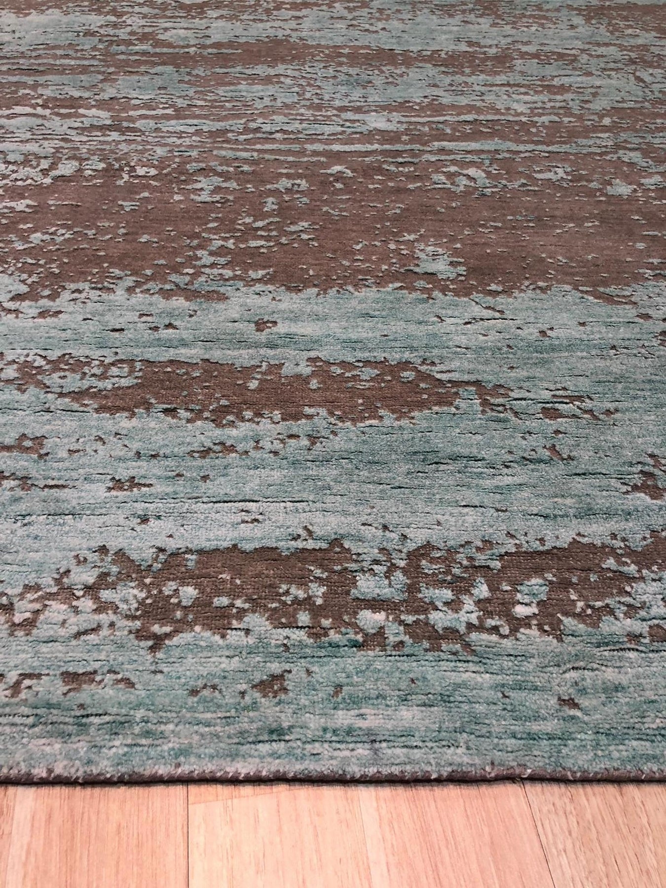 Amara Captivating Silver Hand Knotted Wool Rug, showcasing a detailed, silvery pattern with subtle sheen and intricate hand-knotted construction, displayed in a bright, inviting room setting.