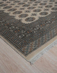 Rustic Nina Beige Nan Rug, capturing a warm, lived-in aesthetic with its subtle beige tones and textured weave, lies centered on a light wood floor, suggesting comfort and understated elegance within a modern space.