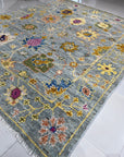 Talia Lila Gray Hand Knotted Wool Rug, showcasing intricate geometric patterns in shades of gray and lilac, elegantly positioned in a living room setting.