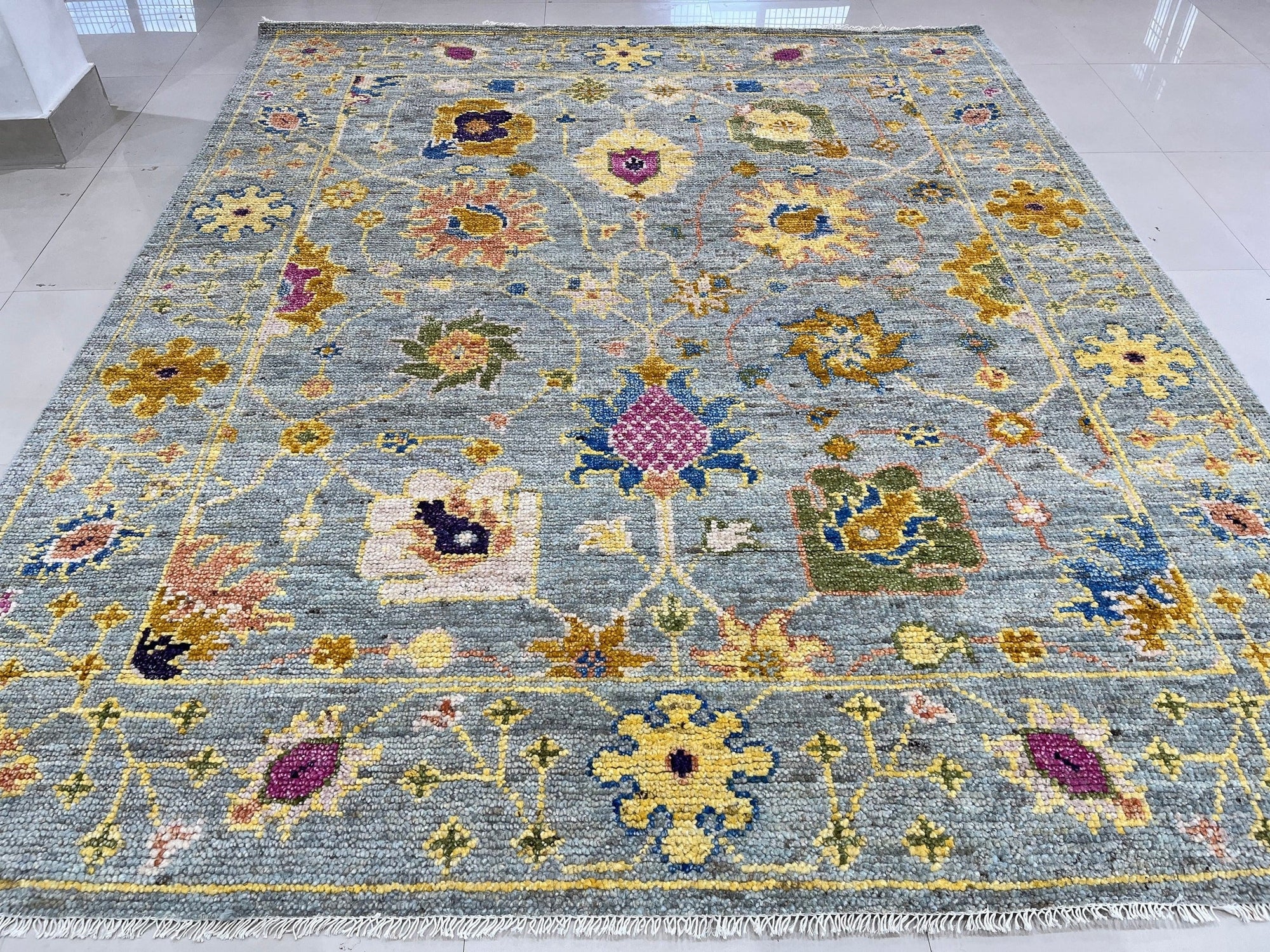 Talia Lila Gray Hand Knotted Wool Rug, blending soft lilacs and grays in a hand-knotted construction, displayed in a bright, modern living space.
