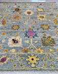 Talia Lila Gray Hand Knotted Wool Rug, blending soft lilacs and grays in a hand-knotted construction, displayed in a bright, modern living space.