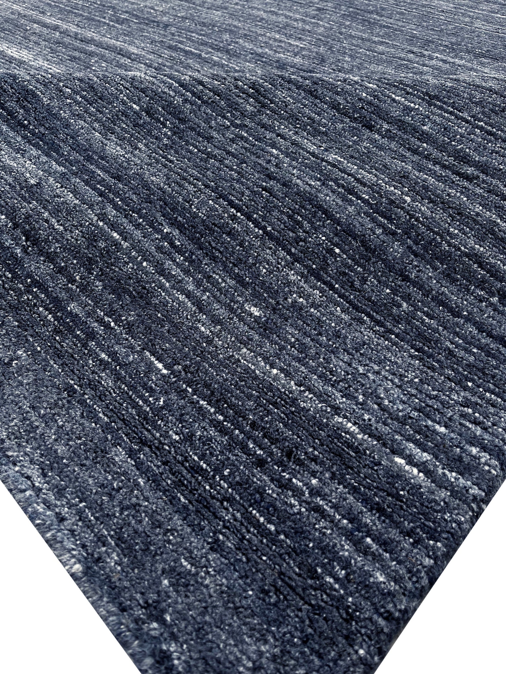 Delicate Striped Charcoal Handmade Wool Rug, its subtle charcoal stripes creating a sophisticated pattern across the soft, handwoven wool, laid against a neutral backdrop.