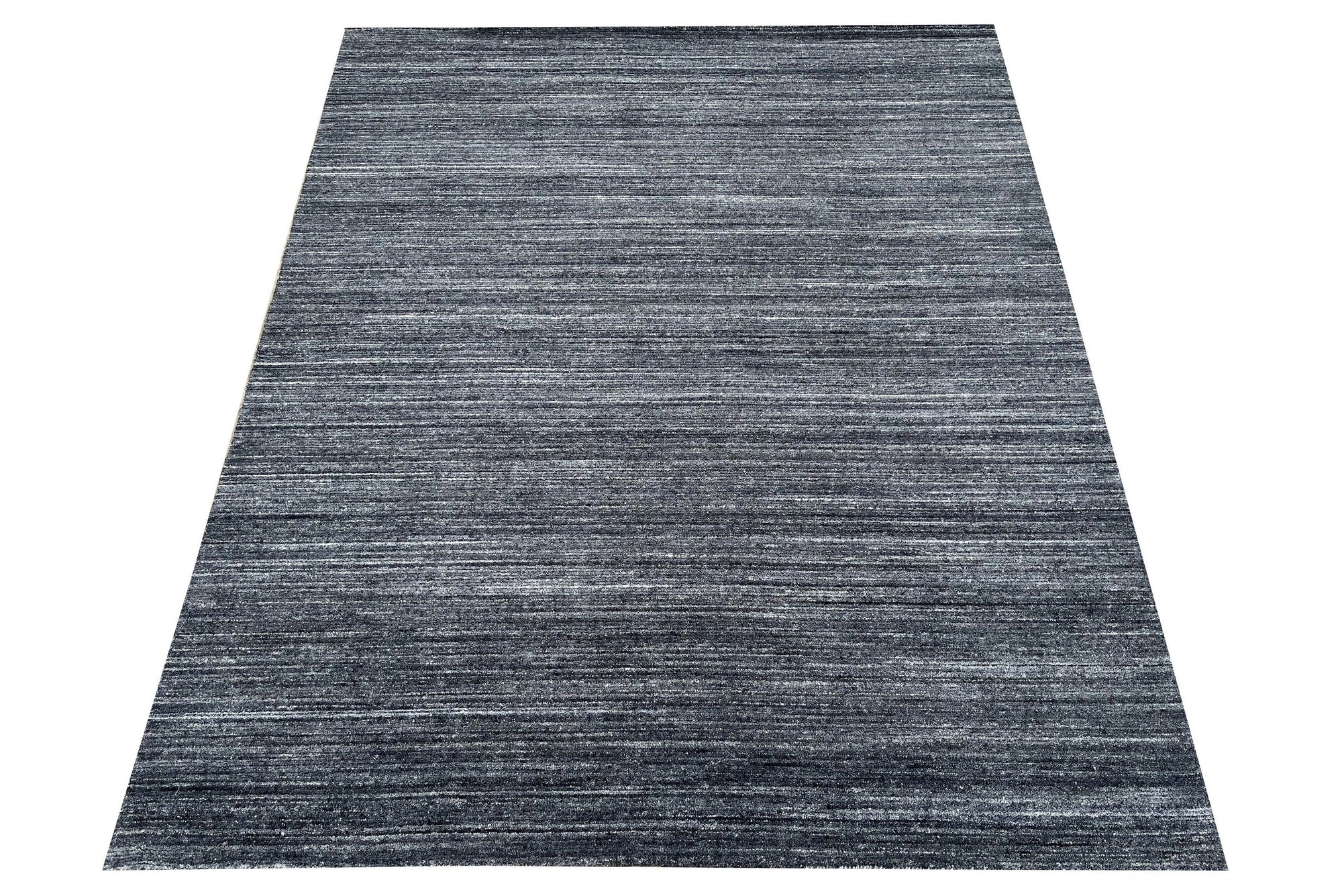 Delicate Striped Charcoal Handmade Wool Rug, its charcoal stripes create a subtle gradient across the hand-knotted wool surface, adding depth and texture to a room setting.