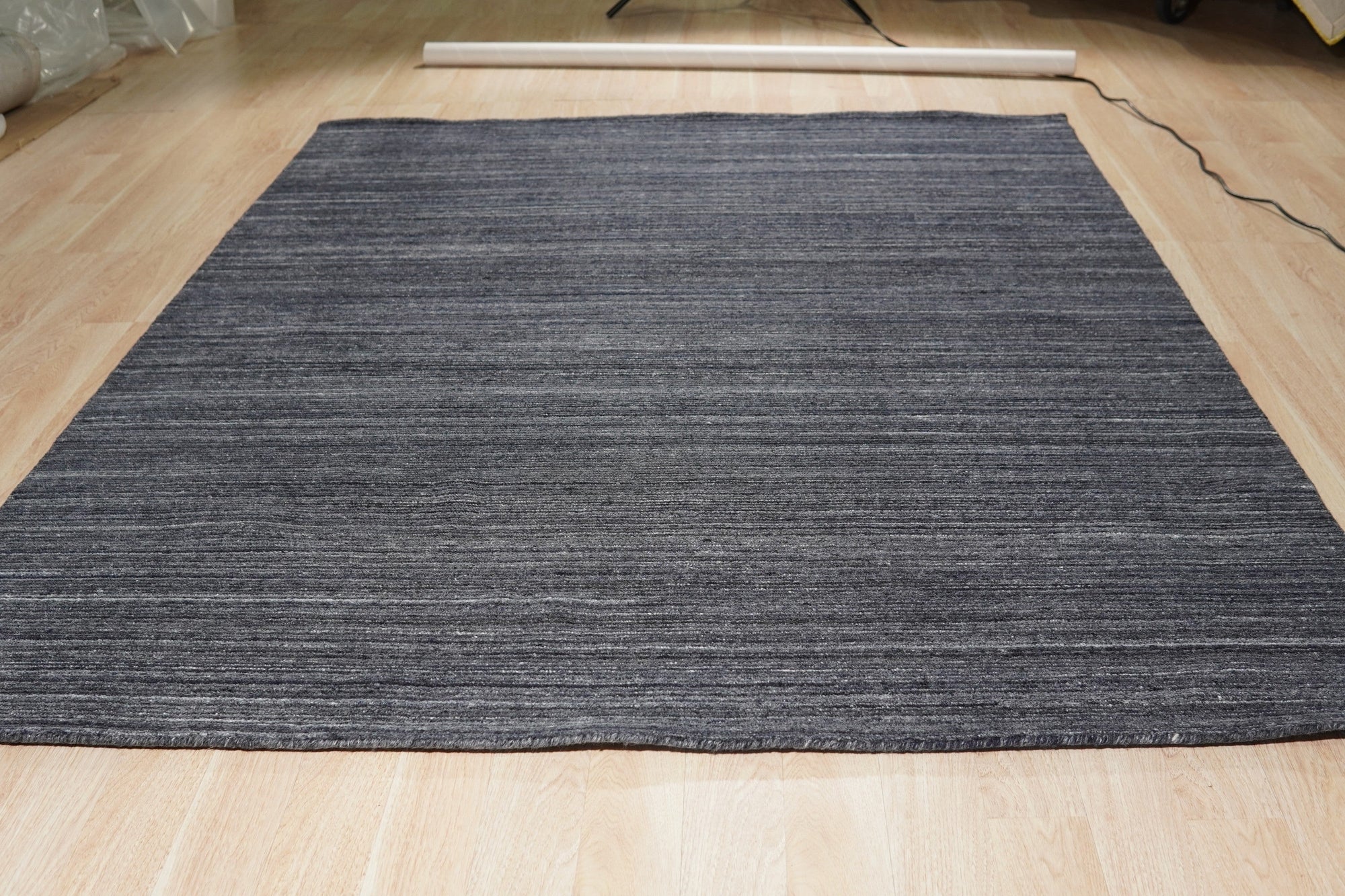 Delicate Striped Charcoal Handmade Wool Rug, with subtle charcoal stripes and a soft wool texture, shown in a modern living room setting, enhancing the space with its understated elegance.