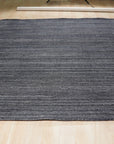 Delicate Striped Charcoal Handmade Wool Rug, with subtle charcoal stripes and a soft wool texture, shown in a modern living room setting, enhancing the space with its understated elegance.