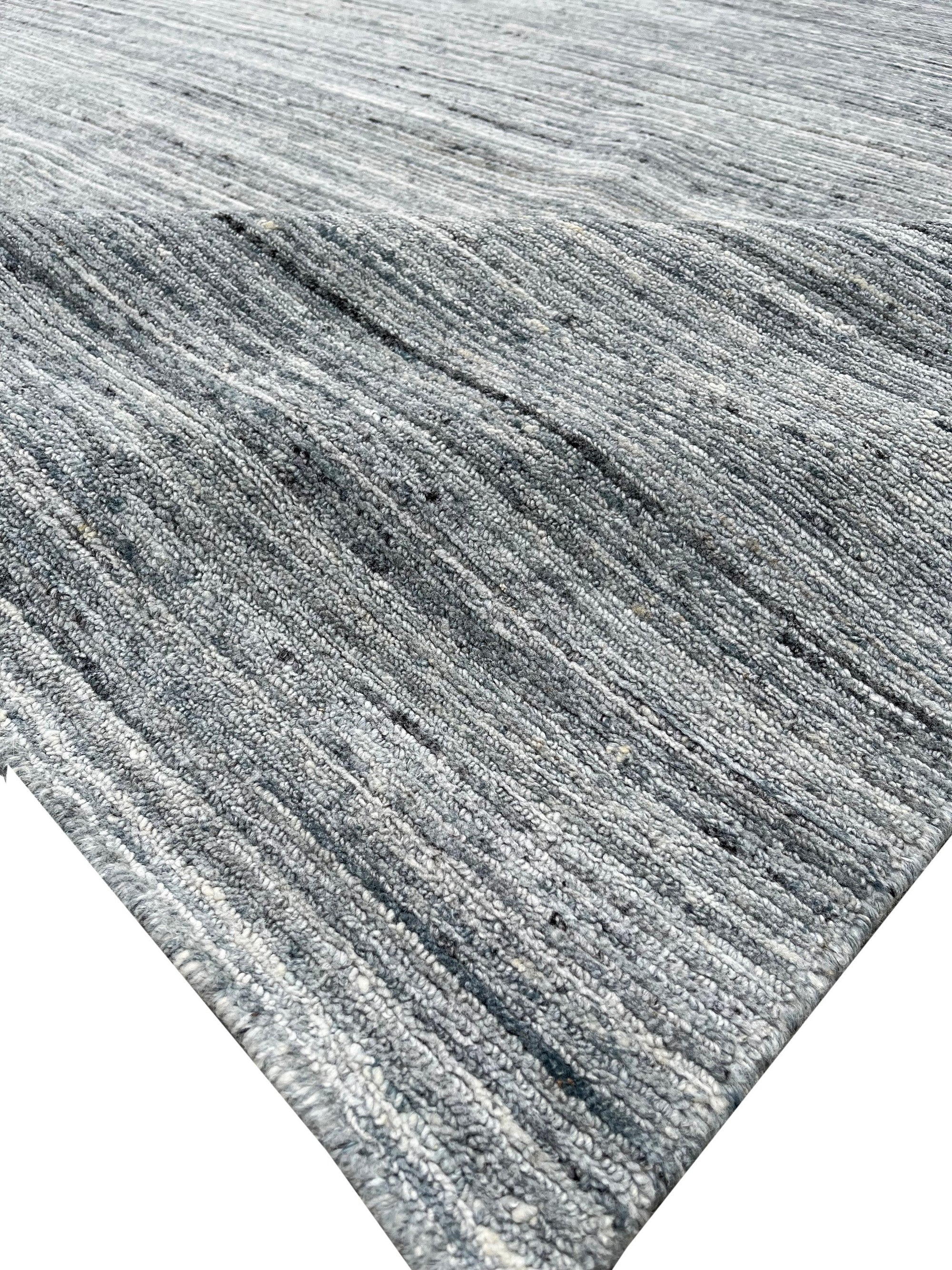 Delicate Striped Gray Handmade Wool Rug, displaying subtle gray stripes in a warm, inviting living space.