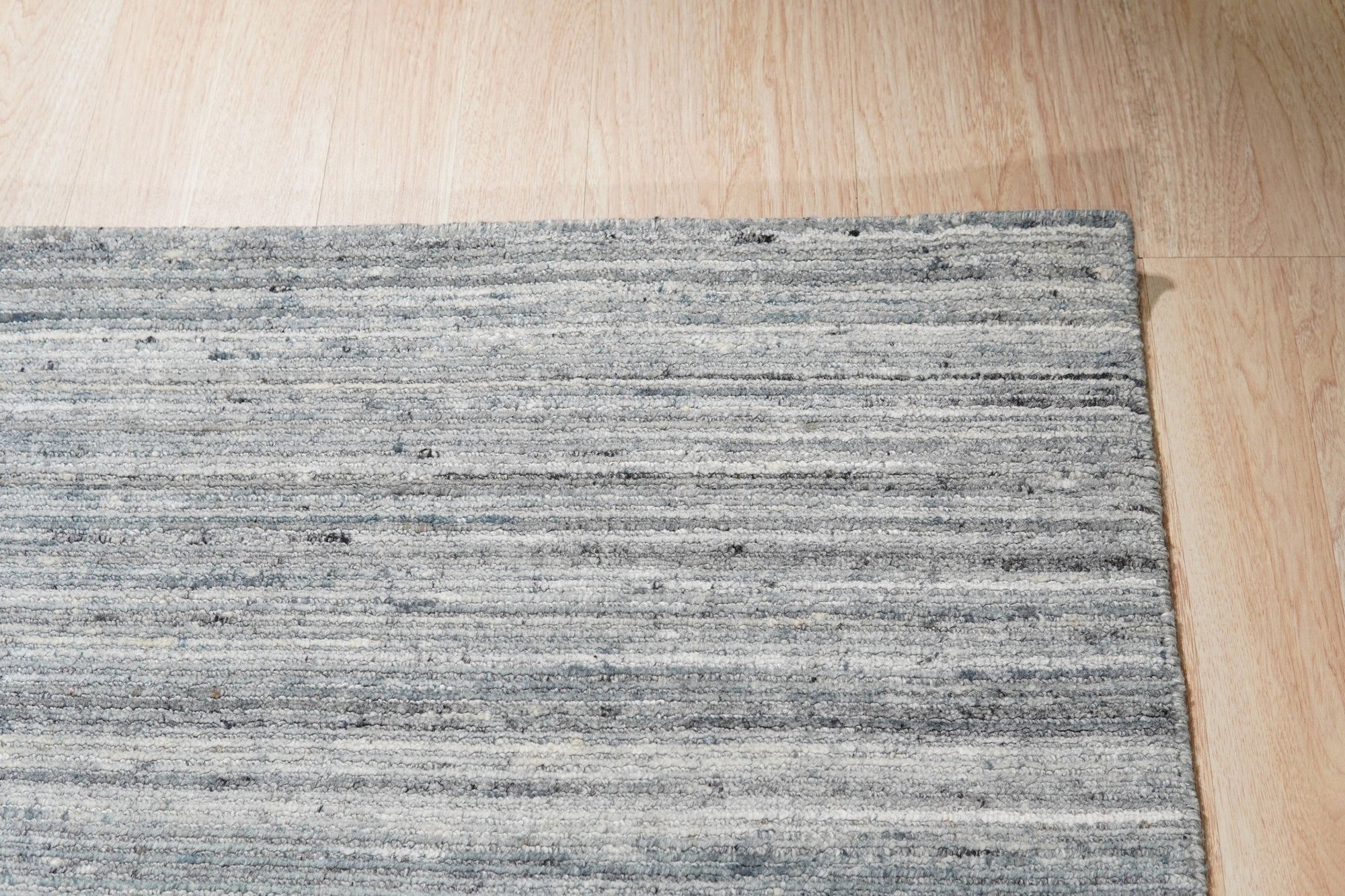 Delicate Striped Gray Handmade Wool Rug in a bright living space, showing a subtle striped pattern and soft texture underfoot.