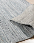 Delicate Striped Gray Handmade Wool Rug displayed in a bright room; its gray and cream stripes offer a subtle, textural contrast, highlighting the rug's handmade wool construction and soft, inviting appearance.