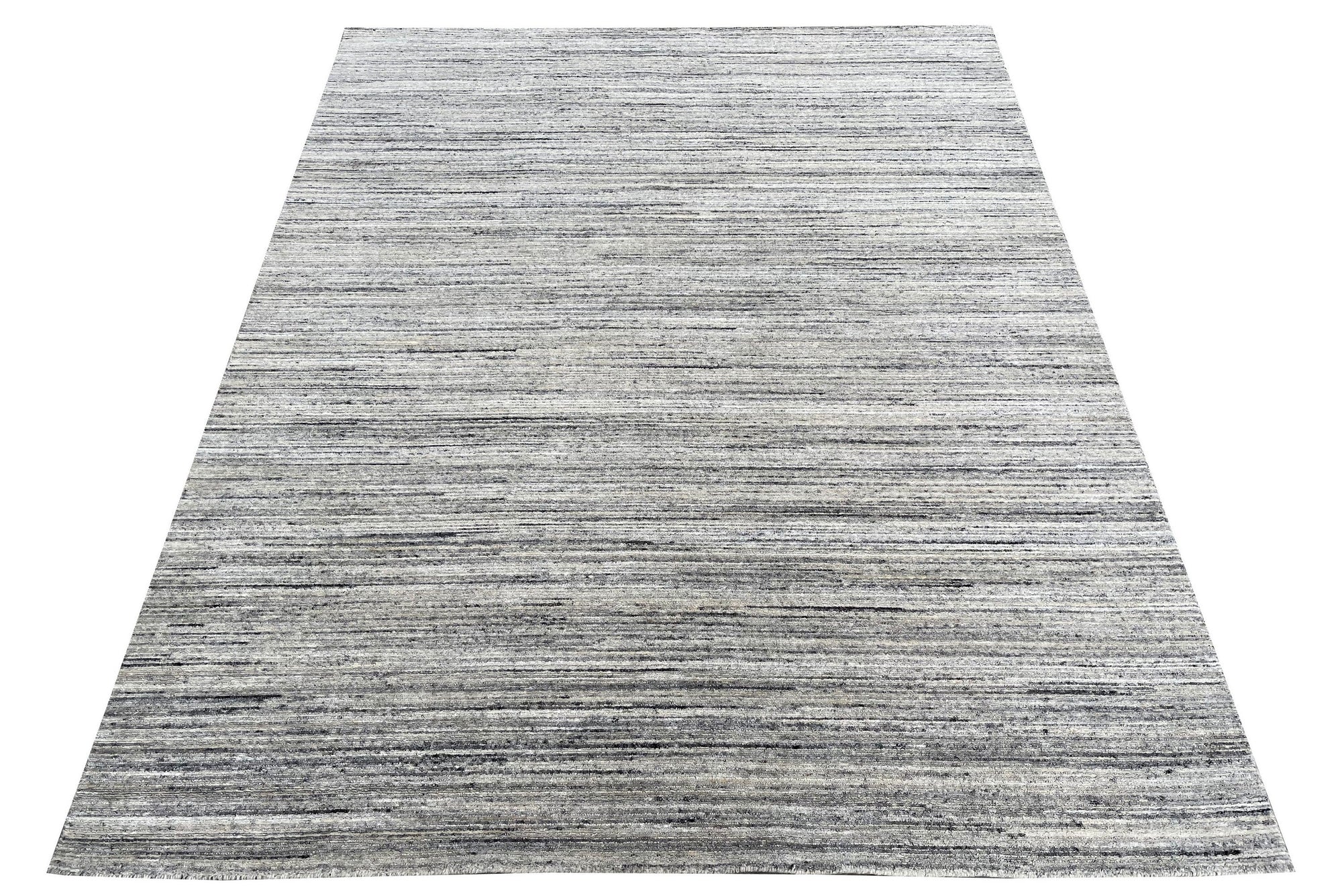Delicate Striped Ivory Handmade Wool Rug displayed in a bright, airy living room setting. Soft ivory wool rug features subtle, elegant stripes. Handcrafted construction evident in the rug's texture and detail.