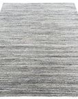 Delicate Striped Ivory Handmade Wool Rug displayed in a bright, airy living room setting. Soft ivory wool rug features subtle, elegant stripes. Handcrafted construction evident in the rug's texture and detail.
