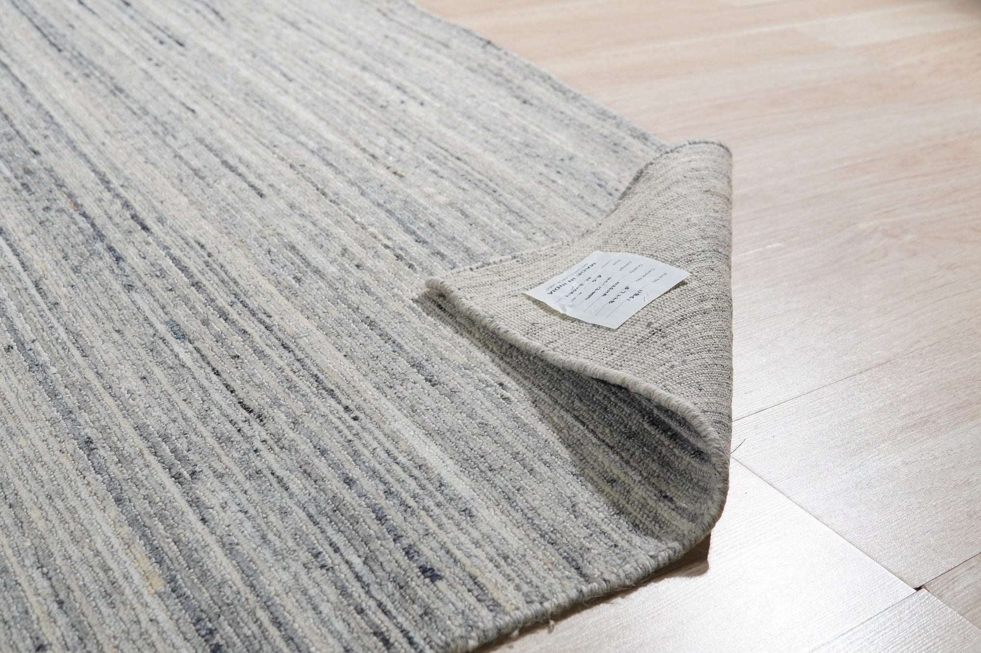 Delicate Striped Ivory Handmade Wool Rug, soft ivory wool with subtle stripes, presented in a bright, inviting living space.