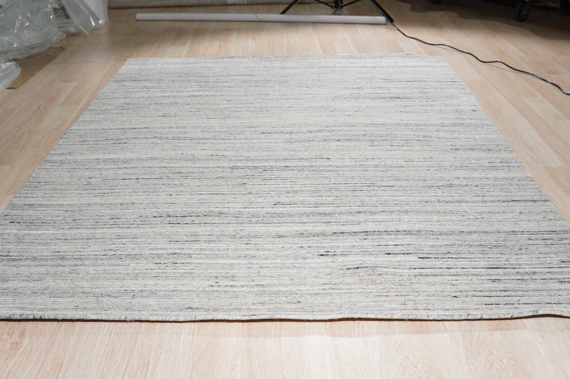 Delicate Striped Ivory Handmade Wool Rug, showcasing soft ivory stripes handwoven in wool, creating a subtle textural pattern in a bright, modern room setting.