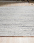 Delicate Striped Ivory Handmade Wool Rug, showcasing soft ivory stripes handwoven in wool, creating a subtle textural pattern in a bright, modern room setting.