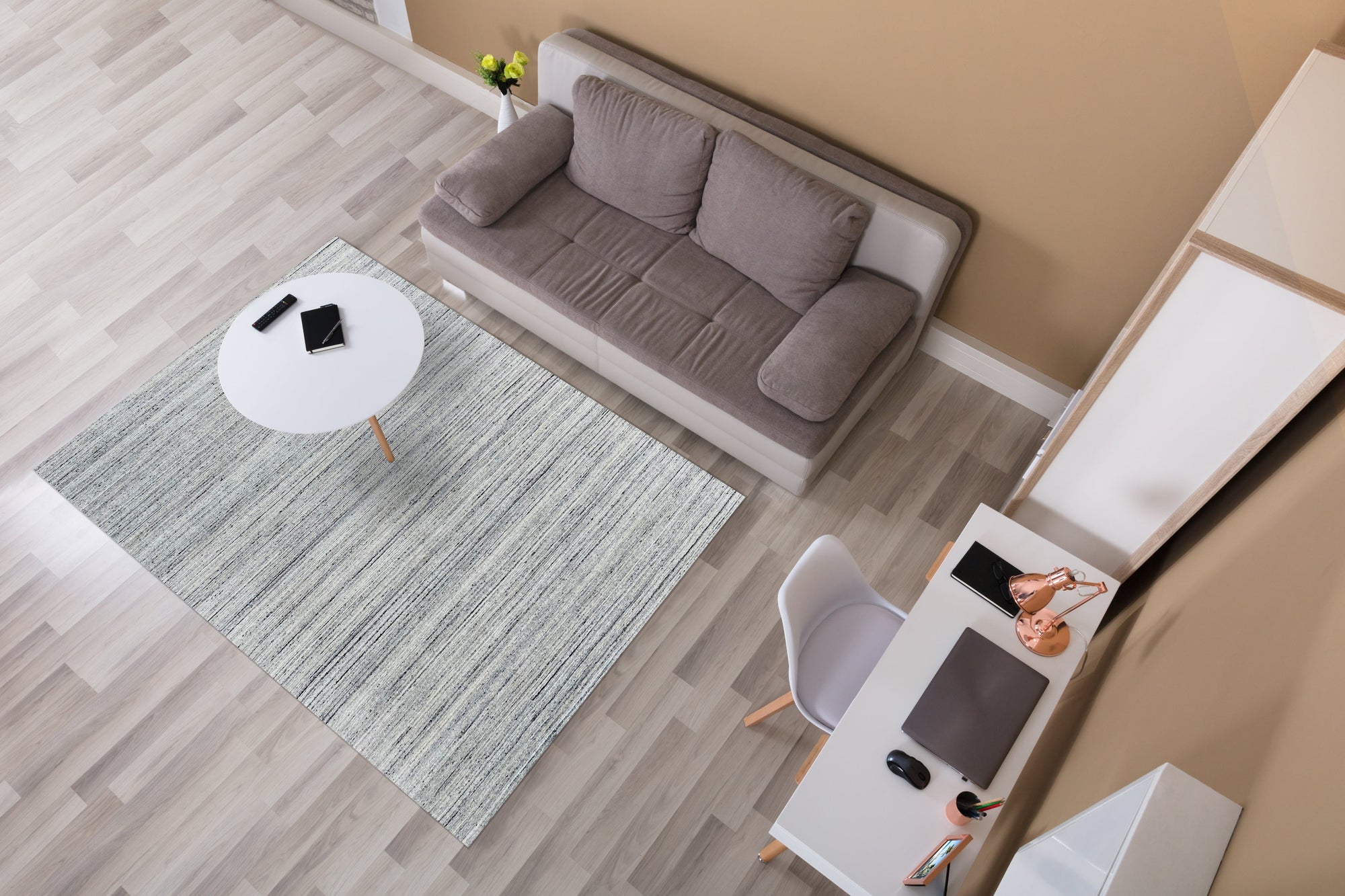 Delicate Striped Silver Handmade Wool Rug, displayed in a brightly lit room, features shimmering silver stripes woven into a soft, woolen texture, creating a modern, yet inviting floor covering.