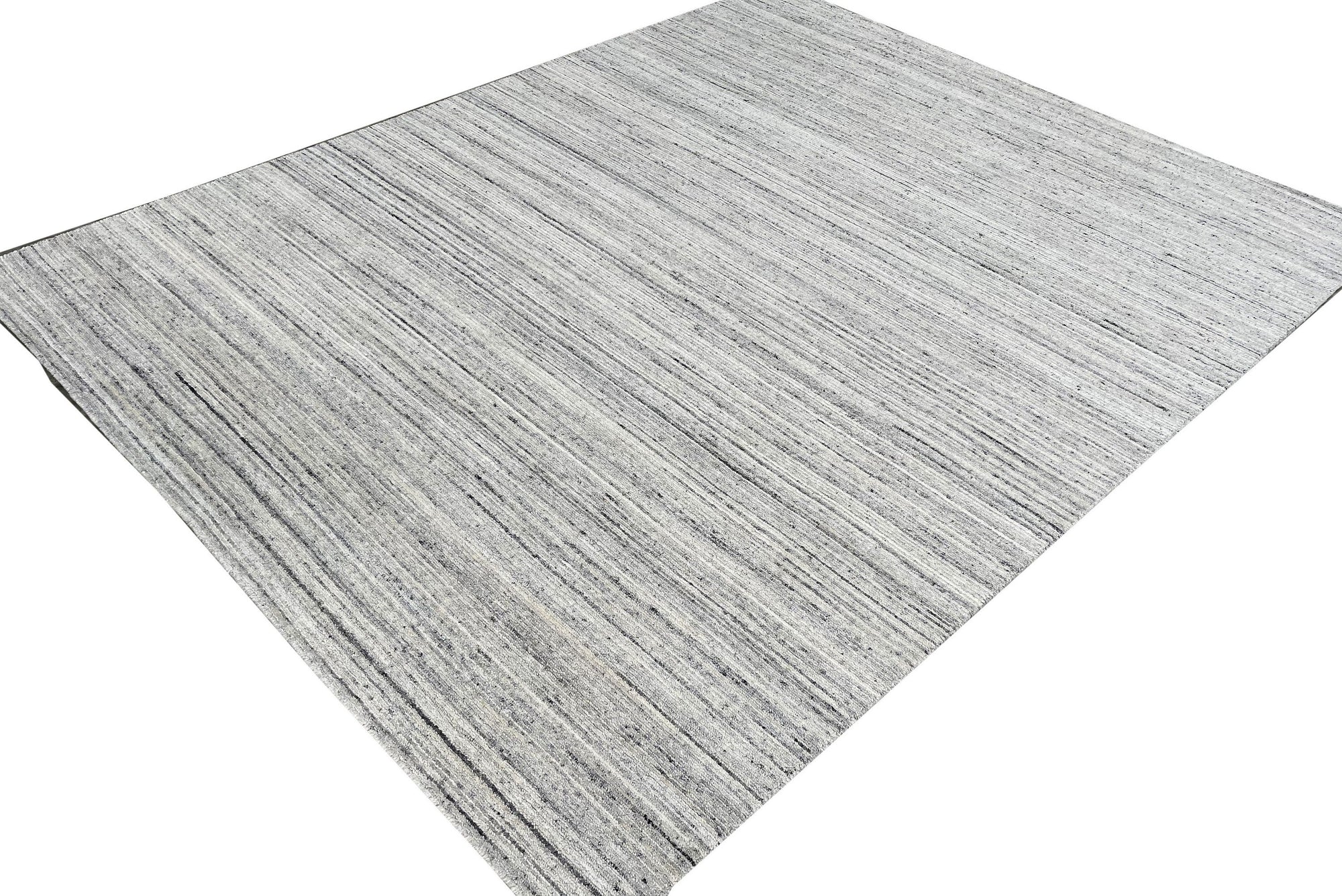 Delicate Striped Silver Handmade Wool Rug, showcasing subtle striations of silver and neutral tones in a detailed wool weave, bringing sophisticated texture to a contemporary living space.
