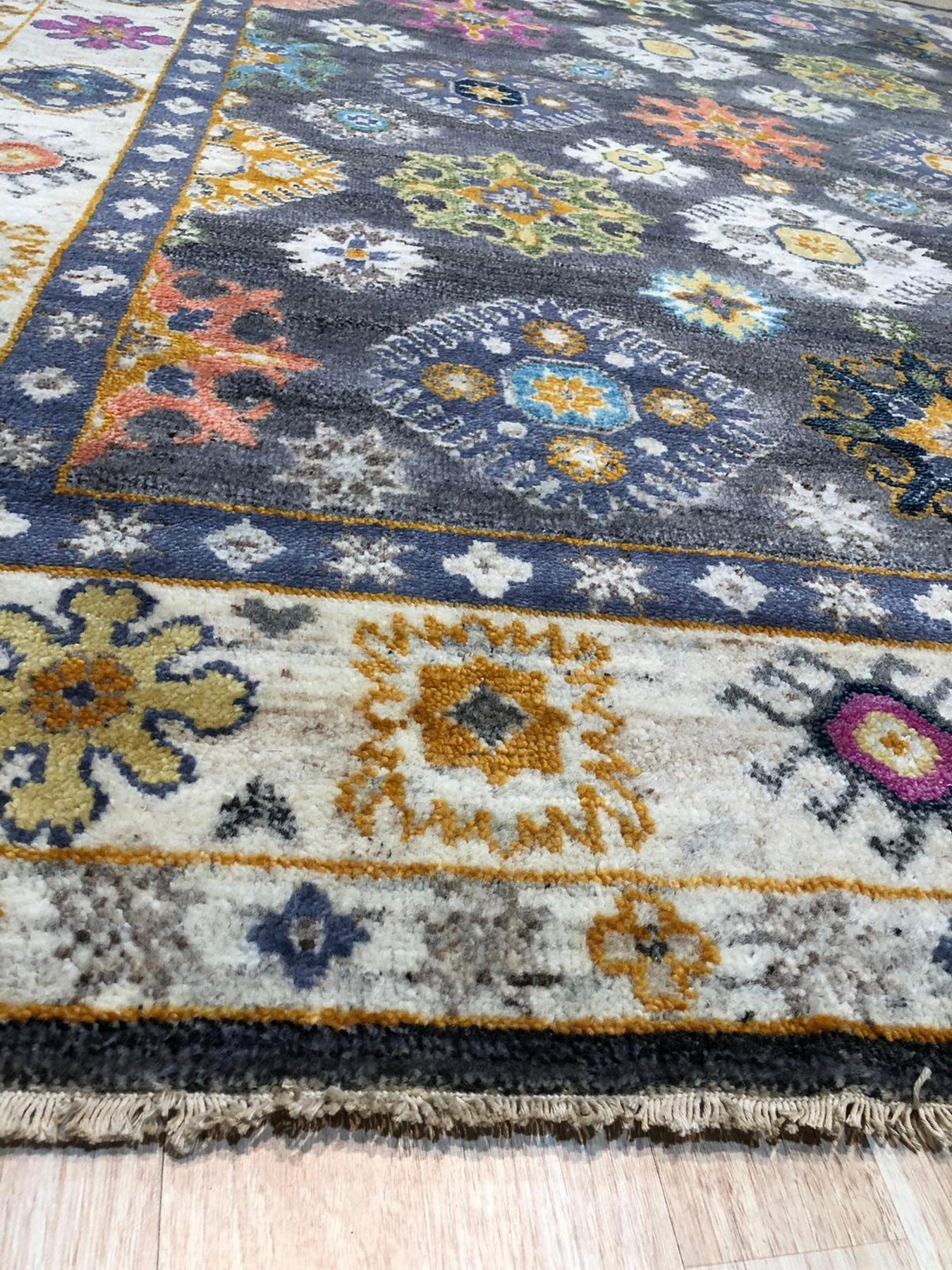 Lila Ruby Charcoal Hand Knotted Wool Rug displayed in a bright living room setting. Deep charcoal hues and ruby accents create a sophisticated contrast in this hand-knotted wool rug.