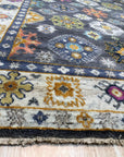 Lila Ruby Charcoal Hand Knotted Wool Rug displayed in a bright living room setting. Deep charcoal hues and ruby accents create a sophisticated contrast in this hand-knotted wool rug.